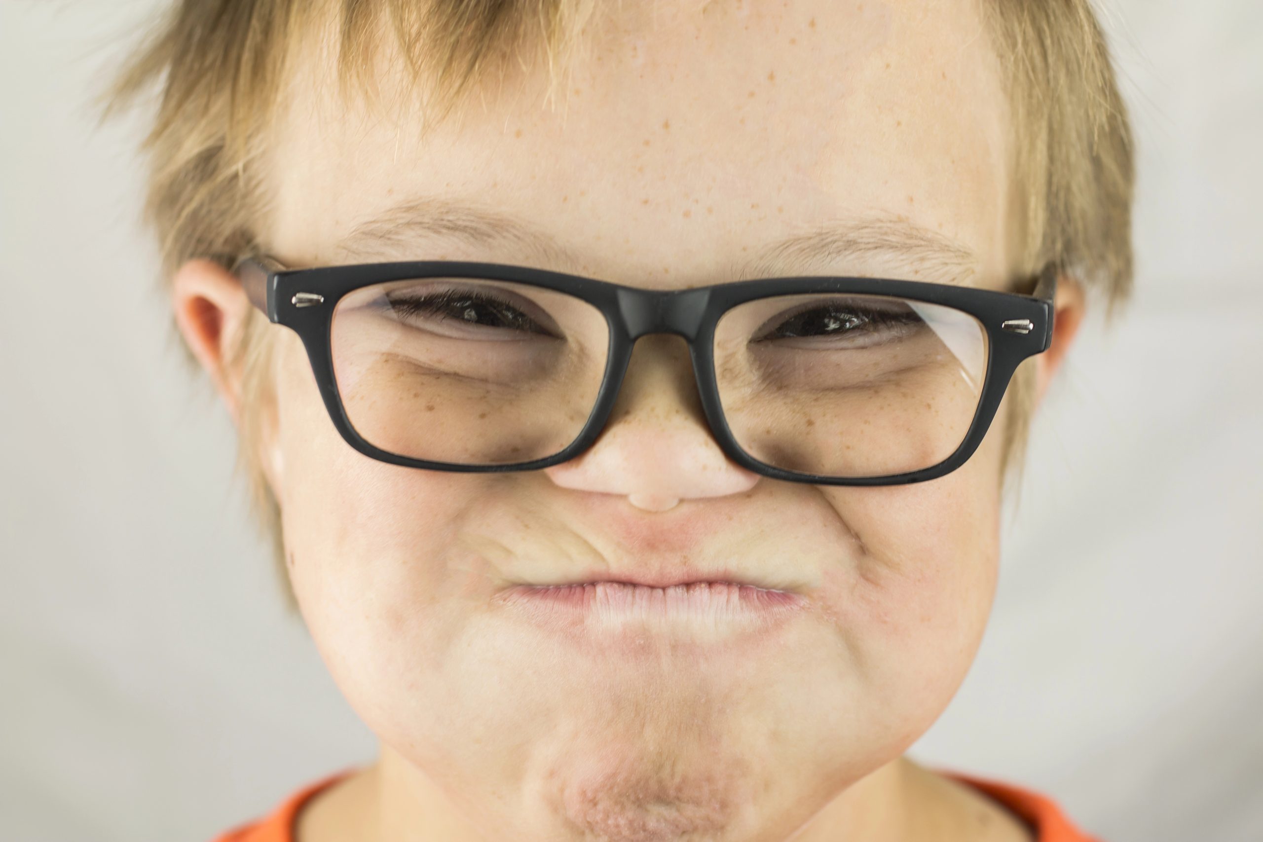 Young child with Down syndrome smiling in a group